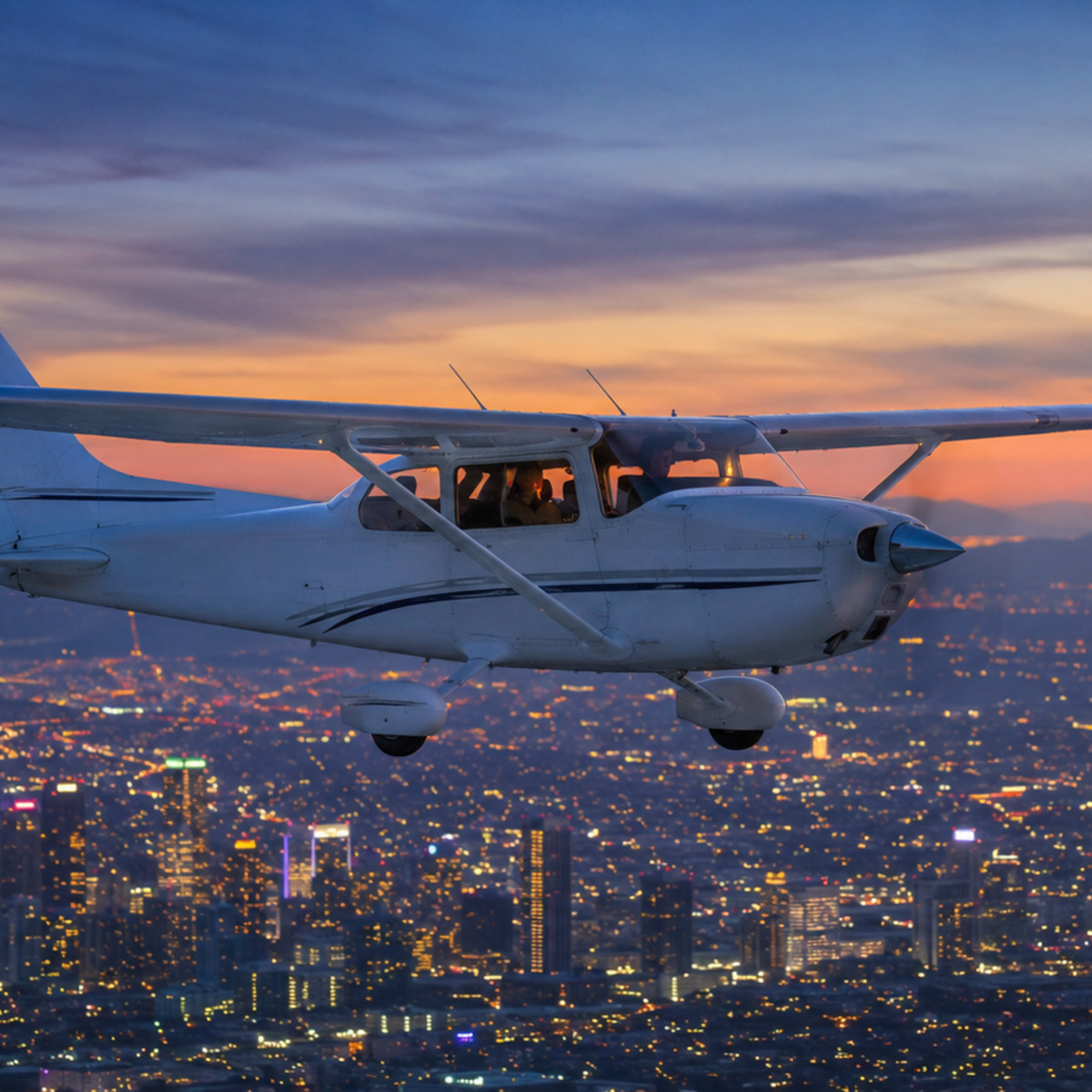 Cloud Aviation Cessna flying over the Los Angeles skyline at dusk on a sunset night flight